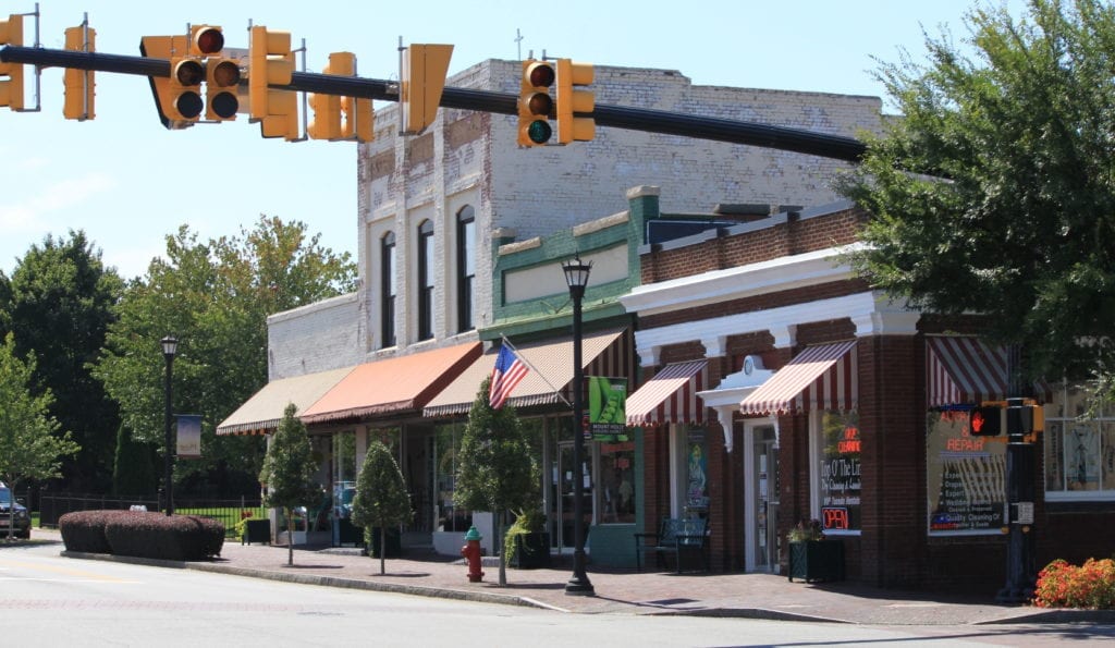 A street intersection with stoplight in Mount Holly, North Carolina shows small shops