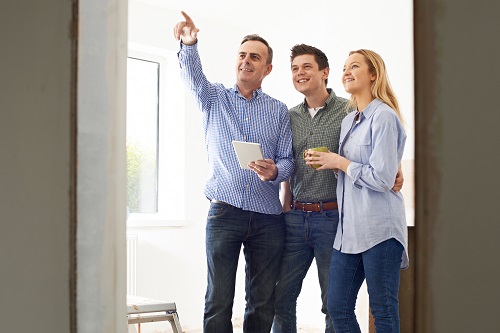Homebuilder showing a couple around a new home - Home Building Checklist Blog